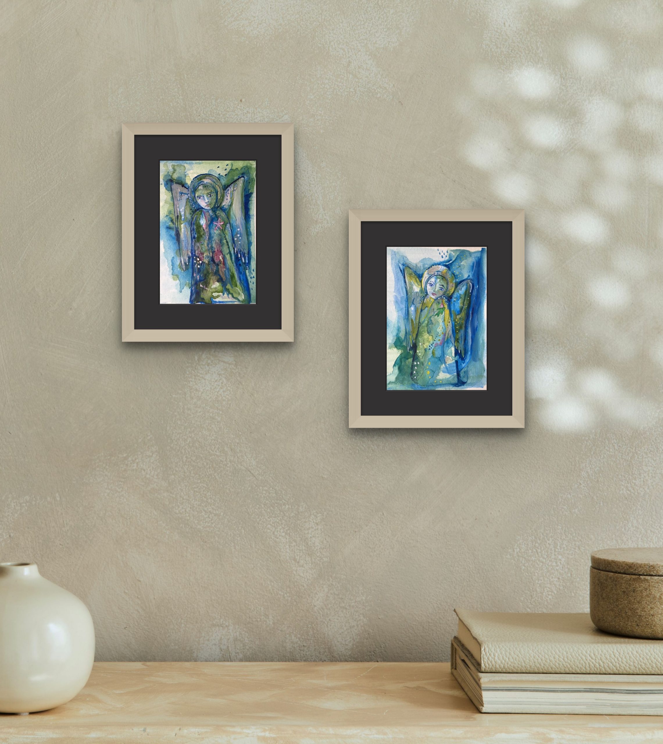 A pair of ocean angel paintings Both painted in layers of green and blues. One with a fish motif the other with a starfish motif.