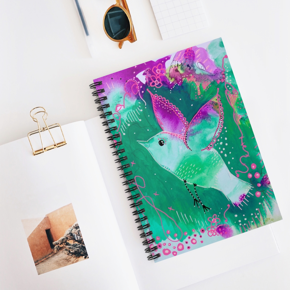 bird journal in context. Bird flying is created from green and violet tones that match her background.