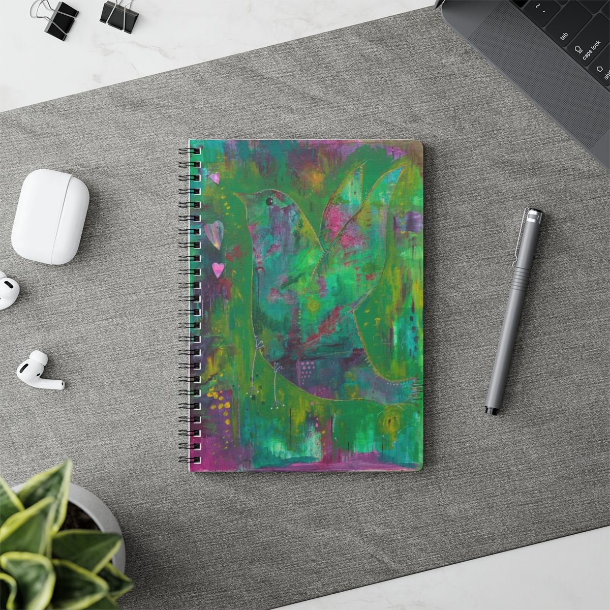 Special bird notebook in context. Whimsical abstract bird taking flight created using layers of green and purple acrylic paints.