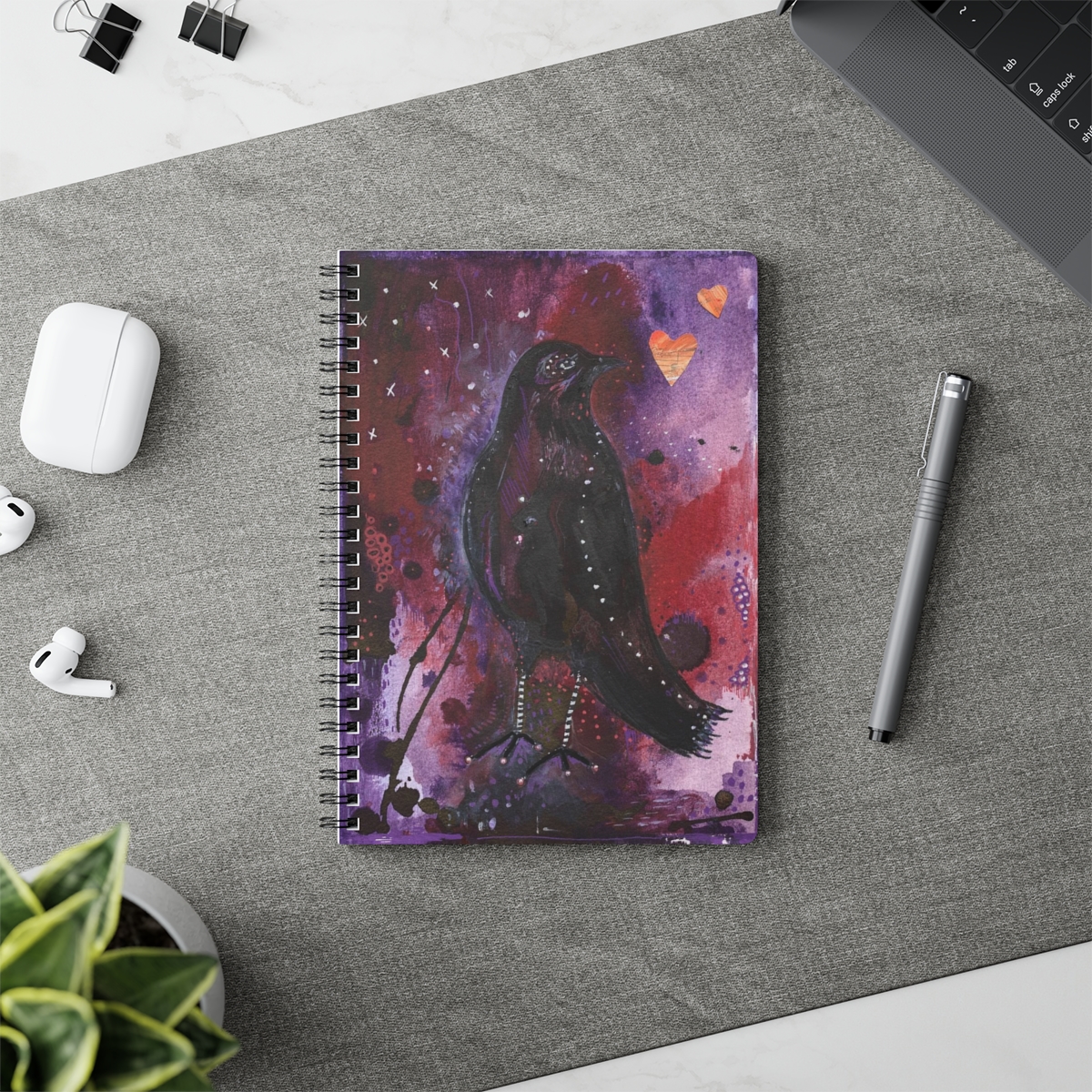 Special notebook in context- crow design on an abstract background of purple tomes.