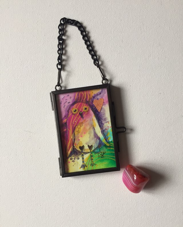 Miniature Owl - spread a little happiness. Whimsical owl painted with rainbow inspired colours on an abstract background. Pink crystal added to show size.