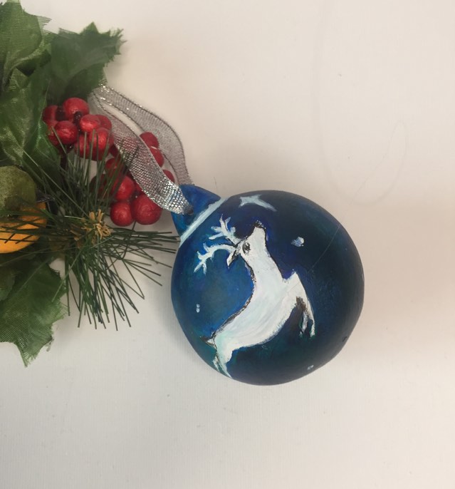 Teal blue beautiful keepsake Christmas bauble with silver ribbon. Hand painted with a white reindeer leaping through the sky towards a white star.