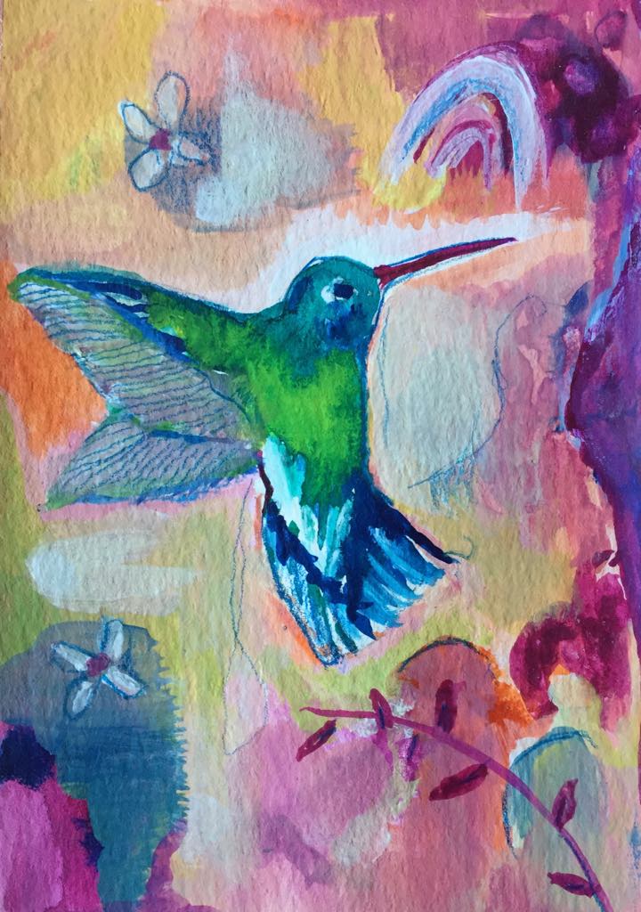 Magical hummingbird art - this painting shows a green and blue hummingbird hovering. Behind her ther is an abstract background of sof pastel pinks andn peaches. Above the hummingbird is a rainbow motif