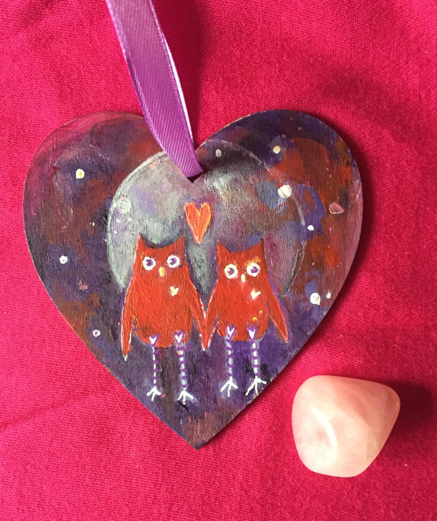 hand painted wooden heart with 2 whimsical owls walking hand in hand against an ethereal full moon and purple night sky.